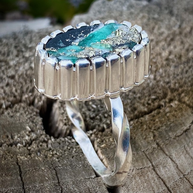  This magnificent ring was created by Robert Lopez and features a natural surface Emerald, Pyrite and Quartz on black Schist.  